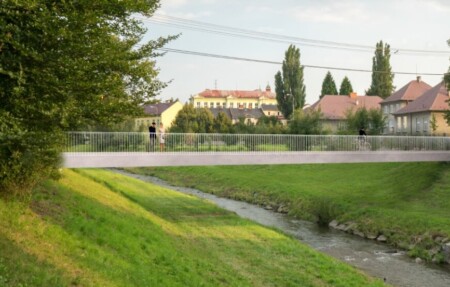 Říčku Jičínku v ulici Novosady přemostí nová lávka. Ta stávající, zejména její ocelová konstrukce, je v havarijním stavu. Město oslovilo tři architektonické ateliéry, aby zhotovily návrhy na podobu nové lávky i její napojení na přístupové komunikace. Odborná komise vybrala návrh ateliéru Blank architekt, s.r.o., který zároveň připraví i projektovou dokumentaci. Ta by se měla zpracovat v příštím roce a následně dojde k samotné výstavbě lávky a revitalizaci jejího okolí. „Na ateliéry jsme se obrátili proto, abychom získali co nejlepší návrh architektonicko-konstrukčního řešení nové lávky. Součástí našeho požadavku bylo i bezpečnější řešení křižovatky ulic Nábřežní a Novosady, využití mostu pro chodce i cyklisty a jeho nasvětlení. Také jsme chtěli, aby se v rámci revitalizace okolí lávky zhotovilo nové kontejnerové stání pro odpadní nádoby v Nábřežní ulici a vybudovala asi 50 metrů dlouhá zpevněná stezka pro pěší od ulice Novosady směrem k obchodnímu centru Tabačka,“ uvedla Lenka Ondřejová z odboru rozvoje a investic na novojičínské radnici. Vítězné studio navrhlo rozšířit průchod lávky na tři metry, počítá s délkou necelých 41 metrů. Mostek je umístěn o metr výše než ten stávající, aby splňoval požadavky Povodí Odry. „Subtilní a lapidárně tvarovaná ocelová konstrukce svým materiálem odkazuje na historii regionu. Jednoduché konstrukční a technologické řešení bylo zvoleno s ohledem na minimalizaci cenových nákladů a zpřístupnění zakázky co nejširšímu okruhu potenciálních zhotovitelů stavby. Konstrukce má i minimální nároky na údržbu,“ dodala Ondřejová. Stávající lávka přes říčku Jičínku byla postavena v roce 1984. Revizní prohlídka v prosinci 2019 odhalila, že ocelová konstrukce mostku je v havarijním stavu. Lávka musí být odstraněna a nahrazena novou.